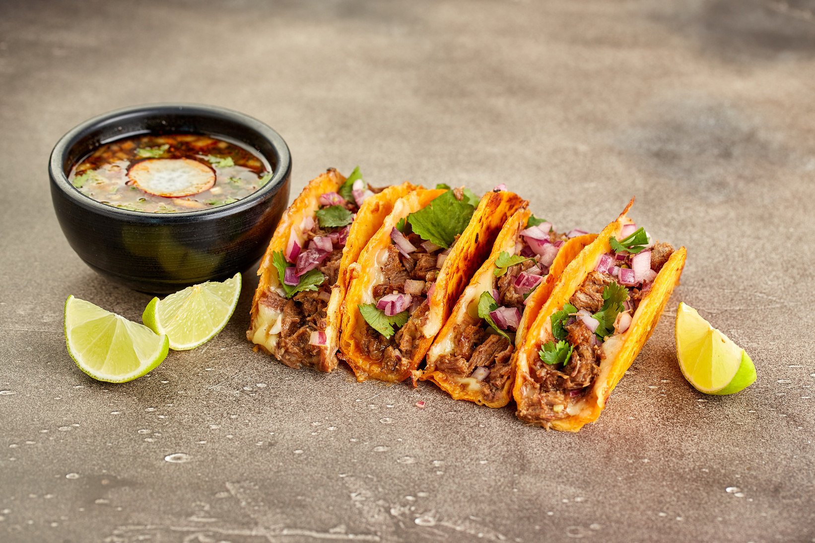 Traditional Mexican Birria Consome Soup and Four Taco with Stewed Beef