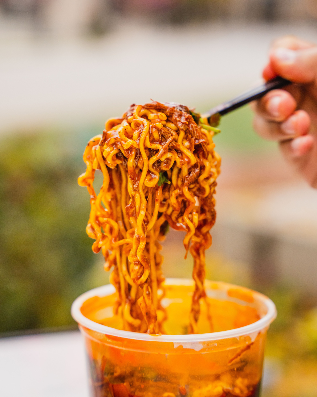 Vertical closeup of a birria ramen on a fork